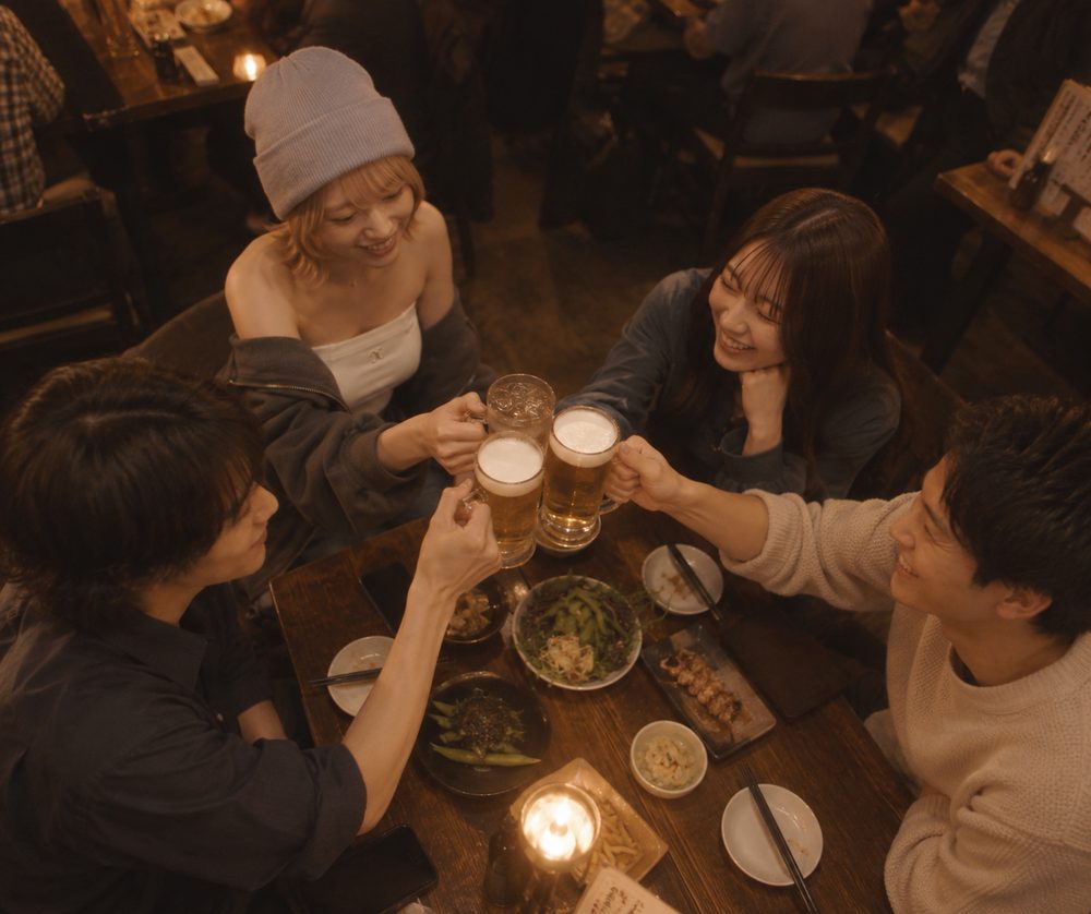 合流した2つのグループがジョッキで乾杯している